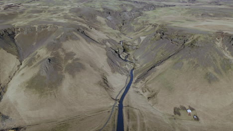 Aerial-View-Of-Icelandic-Mountain-With-Kvernufoss-Waterfall-Running-On-A-Stream-Towards-Skogar-In-Iceland