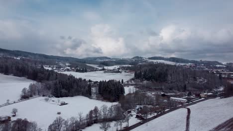aerial-snowy-rural-landscape-of-Czechia-with-beautiful-sky,-pan-left