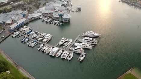 Luxury-Yachts-And-Boats-Moored-On-Jetty-By-Mooloolaba-River-With-Seafood-Restaurant-At-Sunrise-In-QLD,-Australia