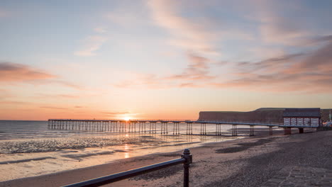 North-York-Moors,-Teesside,-Saltburn-By-The-Sea-Time-Lapse---Dawn-to-Sunrise,-from-promenade-looking-towards-pier-and-huntcliff-headland