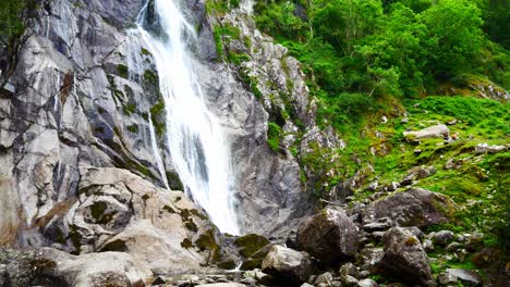Fließender-Felsiger-Bergtalwasserfall-In-Entspannender-Waldlaubwildnis