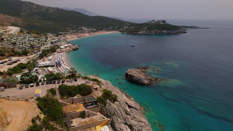 Beautiful-bay-with-resorts-on-sandy-beach-surrounded-by-rocks-and-hills,-emerald-sea-water-in-Jal,-Albania