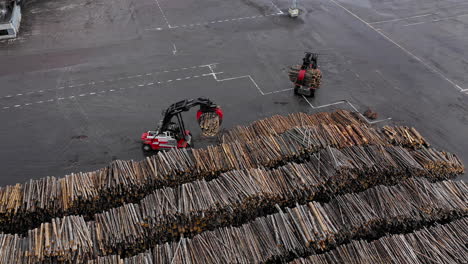 Two-forklift-trucks-tractors-carrying-wood-pilling-pile-lumber-timer-woods-wood-asphalt-cargo-transporting-manufacturing-burning-logs-industrial-industry-bio-fuel-modern-climate-Russian-facility