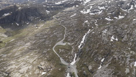 Drone-shot-of-three-cars-driving-on-a-small-road-in-the-beautiful-nature-of-Norway