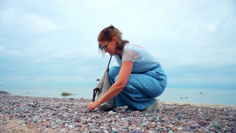 Eine-Erwachsene-Frau,-Die-Steine-An-Der-Küste-Von-Karkle-Beach-In-Litauen-Sammelt