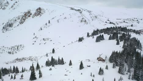 Aerial-View-Of-Cabin-On-Snowy-Hills-At-Winter-Park-In-Colorado-Mountains
