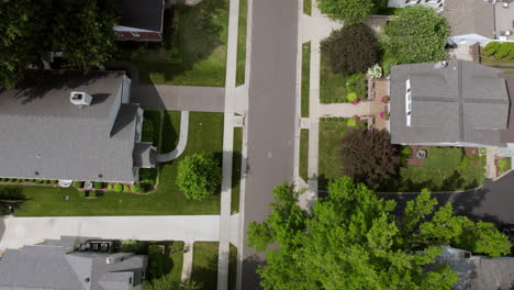 Overhead-a-suburban-street-with-a-tilt-up-to-reveal-the-neighborhood-on-a-pretty-summer-day