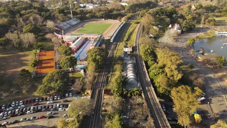 Panoramic-view-of-an-area-of-the-city-of-Buenos-Aires,-capital-of-Argentina,-with-a-modern-train-advancing-at-sunset