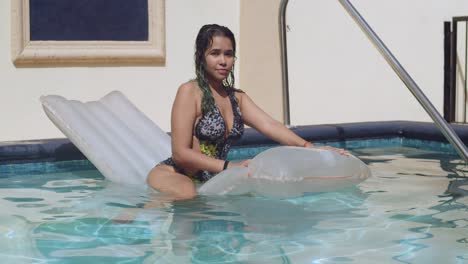 Sexy-Bikini-Model,-Das-Auf-Einem-Schlauchboot-An-Einem-Pool-Schwimmt