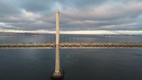 4K-30fps-Aerial-Drone-Close-Up-Flying-Footage-of-San-Francisco-Oakland-Bay-Bridge-Double-Suspension---Cars-Travel-Along-the-Highway,-Stormy-Cumulus-Clouds,-Calm-Bay-Water,-Sunset-Reflecting-off-Waves
