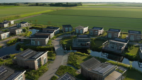 Sonnenkollektoren-In-Den-Hölzernen-Ferienhäusern-Im-Wasserdorf-In-Der-Nähe-Des-Grünen-Farmfields-In-Kamperland,-Niederlande