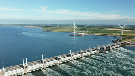 Oosterscheldekering-Dam-And-Coastal-Wind-Turbines-At-Kamperland-Village-In-Zeeland-Province-Of-Netherlands
