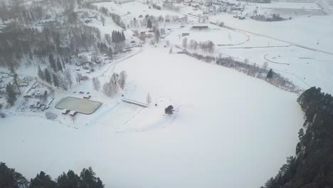 Vuelo-Aéreo-Sobre-Un-Parque-Cubierto-De-Nieve-Con-Un-Campo-De-Hockey-Al-Aire-Libre