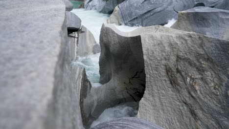 Slow-motion-detail-shot-of-water-flowing-in-small-channels-in-the-mountain