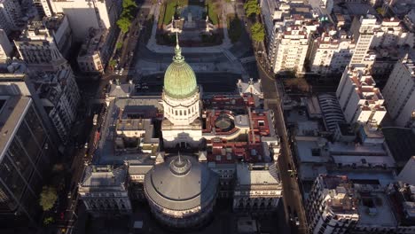 Aerial-tracking-shot-of-Palace-of-the-Argentine-National-Congress-and-traffic-on-road-during-sunset---Buenos-Aires,Capital-of-Argentina