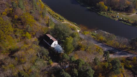 Aufschlussreiche-Luftaufnahme-Eines-Flusses-Nėris,-Der-Sich-Durch-Die-Wunderschönen-Herbstwälder-Von-Vilnius,-Litauen,-Schlängelt