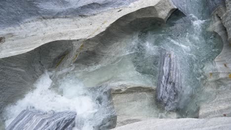 Top-view-of-a-small-stream-of-fresh-flowing-glacier-water,-natural-limestone,-marble-castle,-Norway