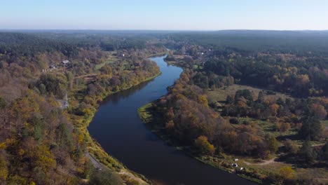AERIAL-Orbiting-Shot-of-a-River-Nėris-Meandering-through-an-Autumnal-Forests-of-Vilnius,-Lithuania