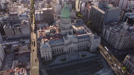 4K-Aerial-shot-of-historic-old-Building-of-National-Palace-Congress-in-Buenos-Aires-during-sunset---Cars-driving-on-narrow-road---Tracking-shot