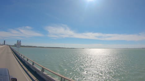 POV-from-roof-top-while-driving-on-Queen-Isabella-Causeway-over-the-Laguna-Madre-at-South-Padre-Island,-Texas