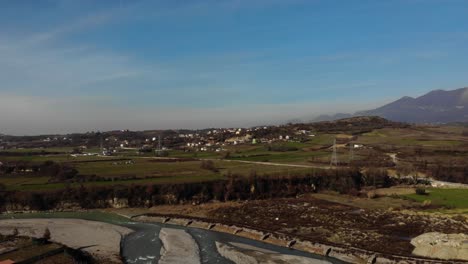 Ländliche-Landschaft-Mit-Dorf-Und-Landwirtschaftlichen-Betrieben-Oberhalb-Des-Flusses-In-Albanien