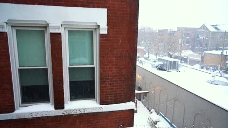 Close-Up-of-Brick-Apartment-Building,-Windows-during-Light-Snowfall-on-Cold-Winter-Day