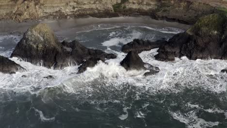Waves-crashing-into-rocks,-Oregon-coast,-aerial-static-view