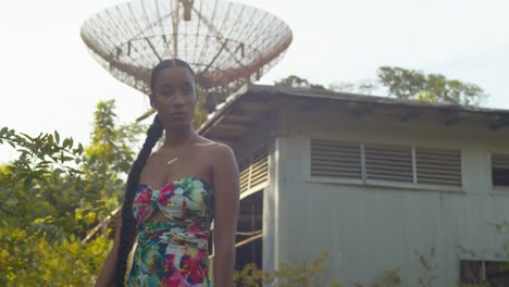A-model-walks-in-the-foreground-with-an-abandoned-radio-tracking-tower-in-the-background-on-the-island-of-Trinidad