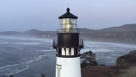 Cinematic-aerial-orbit,-Yaquina-Lighthouse-closeup,-overcast-afternoon-in-Oregon