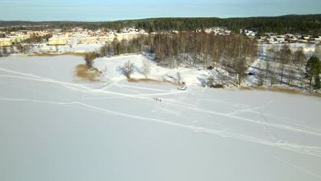 Zwei-Personen-Skifahren-Auf-Einem-Zugefrorenen-See-An-Einem-Kalten,-Sonnigen-Tag