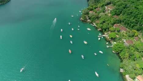 Aerial-drone-shot-of-crowded-place-with-lots-of-boats-and-beautiful-turquoise-calm-sea-near-island-coast-with-green-tropical-vegetation-and-transparent-water