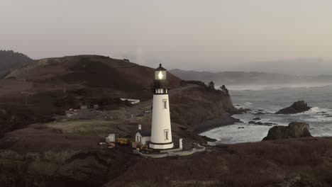 Cinematic-aerial-orbit,-Yaquina-Head-Lighthouse,-circling-around-over-ocean