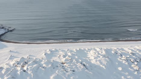 Island-Dünen-Mit-Schnee-Bedeckt-Am-Strand-Von-Sandvik,-Antenne