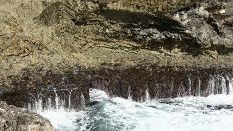 Waves-breaking-on-rocks-into-a-small-blow-hole,-Carribean,-Bonaire