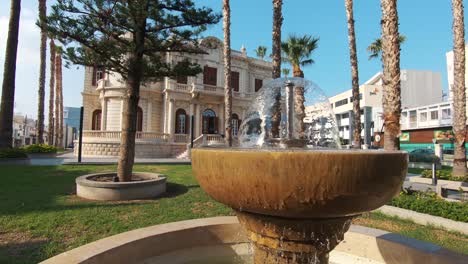 Small-fountain-in-the-garden-adjacent-to-Limassol-Public-Library-in-Cyprus---Wide-Slide-Reveal-shot