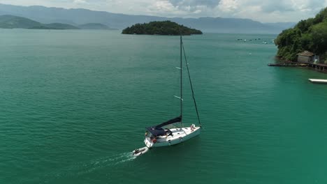Luftdrohnenaufnahme-Eines-Segelbootes,-Das-Auf-Einer-Wunderschönen-Tropischen-Insel-Mit-Einheimischer-Brasilianischer-Vegetation-Und-Wüstenstrand-Ankommt