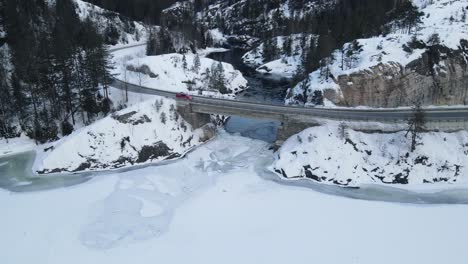 Eine-Brücke-über-Einen-Bergfluss-Und-Einen-Zugefrorenen-See