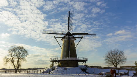 Zeitraffer-Von-Wolken,-Die-über-Eine-Traditionelle-Windmühle-In-Einer-Wunderschönen-Weißen-Ländlichen-Winterlandschaft-Ziehen---Ernte
