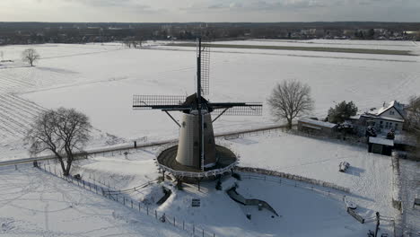 flying-up-to-traditional-windmill-in-rural-snow-covered-landscape