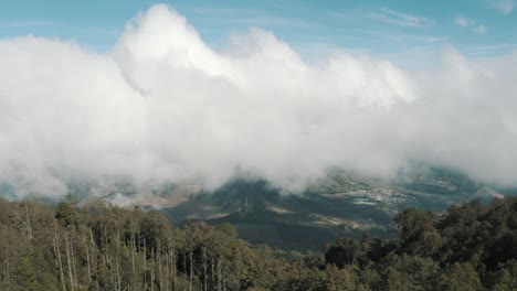 Drone-aerial-view,-flying-high-over-the-forest-of-Acatenango-volcano,-Guatemala,-clouds-moving-during-windy-weather