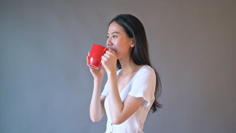 Junge-Asiatische-Frau-Mit-Glücklichem-Gesicht-Und-Hand,-Die-Kaffeetasse-Hält