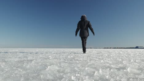 Female-is-walking-on-frozen-surface-of-sea