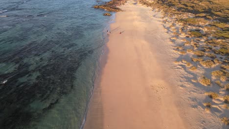 4K-Family-playing-at-deserted-beach-at-sunset-aerial-holiday-time