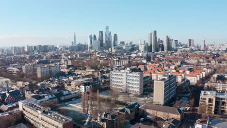 Low-dolly-forward-drone-shot-of-city-of-London-skyscrapers-clear-day-after-snow
