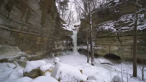 Tiny-frozen-waterfall-while-snowing-in-distance-static-view