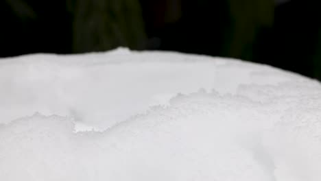 Close-up-of-person-grabing-iced-snow-with-hand-and-forming-snowball