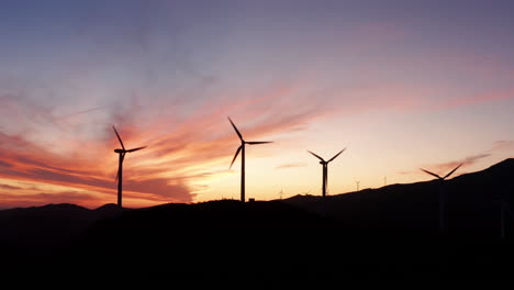 Eine-Lange-Reihe-Wunderschöner-Windmühlenturbinen,-Die-Saubere,-Grüne-Windenergie-Nutzen,-Erheben-Sich-In-Dieser-Atemberaubenden-Silhouettenszene-über-Der-Landschaft