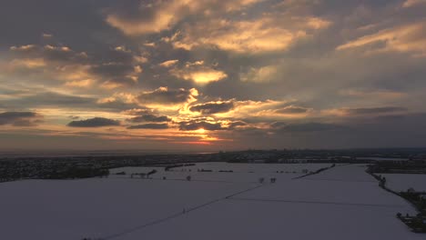 Aerial-shot-sunset-with-dark-shaded-snow-fields-below