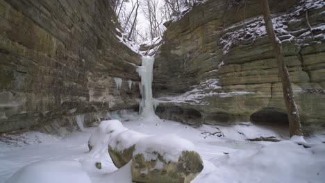 Frozen-waterfall-in-rocky-valley-on-beautiful-snowy-winter-day