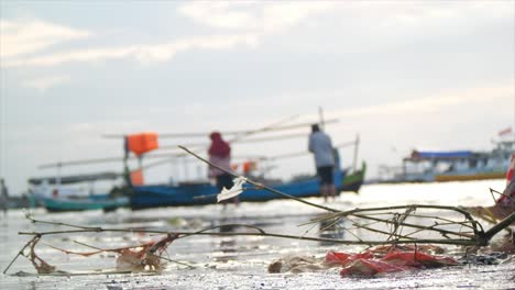Müll-Am-Strand-Mit-Einem-Fischerboot-Im-Hintergrund